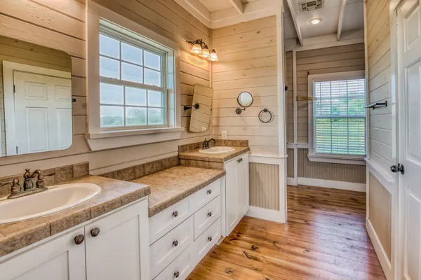 a spacious bathroom with a granite countertop sink mirror and a shower