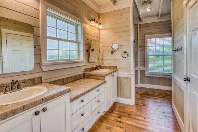 a spacious bathroom with a granite countertop sink mirror and a shower
