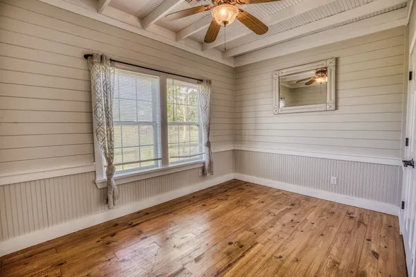 an empty room with wooden floor and windows