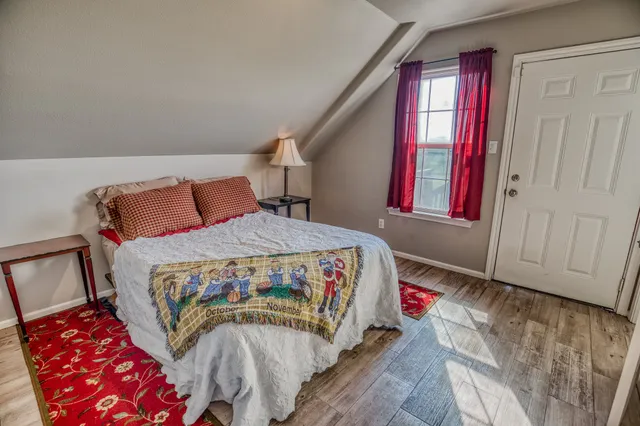 a bedroom with a bed lamp and a large window