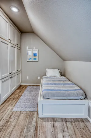 a spacious bedroom with a bed and wooden floor