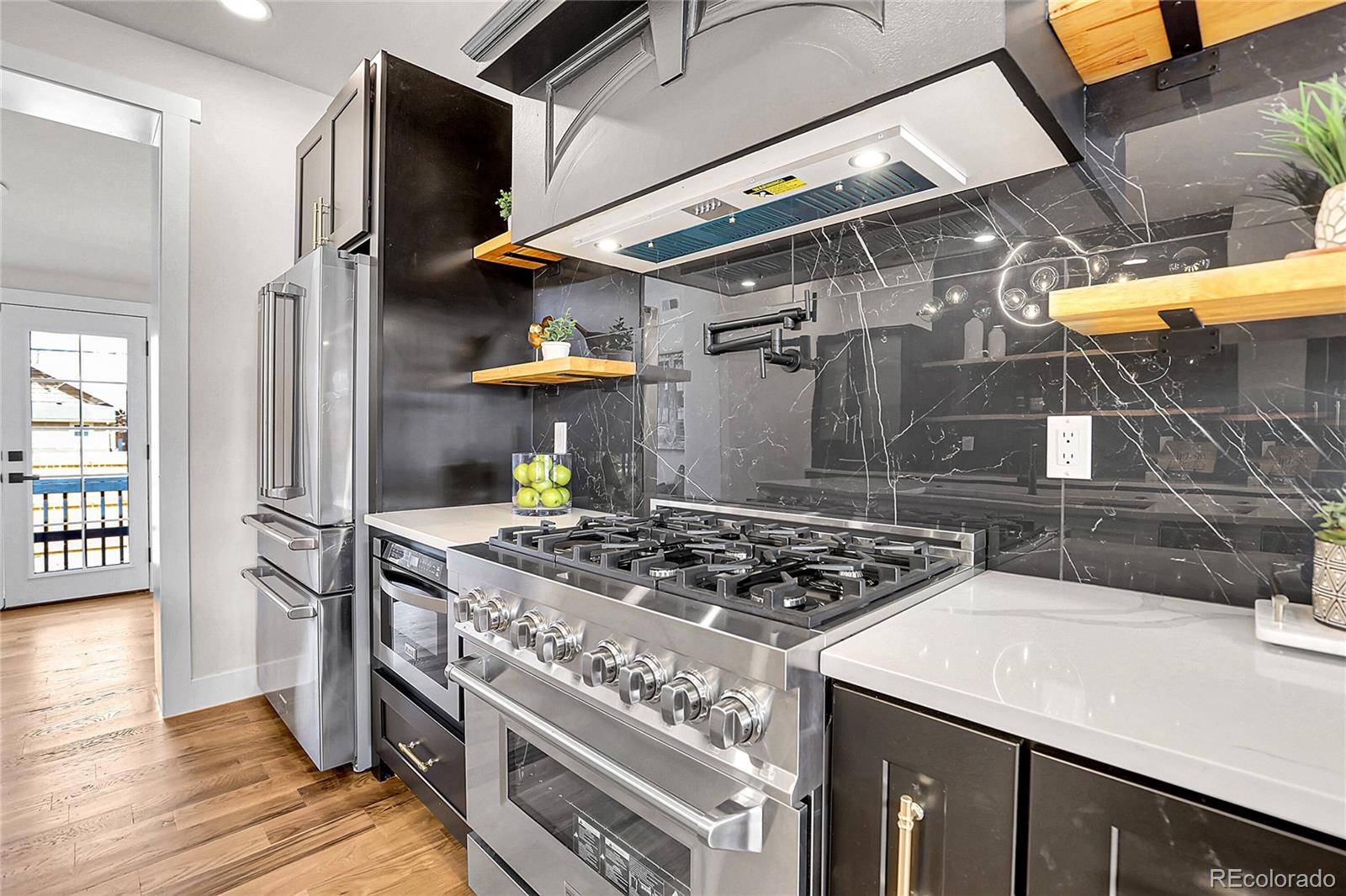 2827 Bellaire Street Denver, CO 80207 - Photo 8 of 31 a kitchen with stainless steel appliances granite countertop a stove and a refrigerator