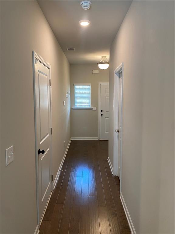 7055 Mimosa Bluff Lithonia, GA 30038 - Photo 7 of 17 a view of a hallway with wooden floor and a bathroom
