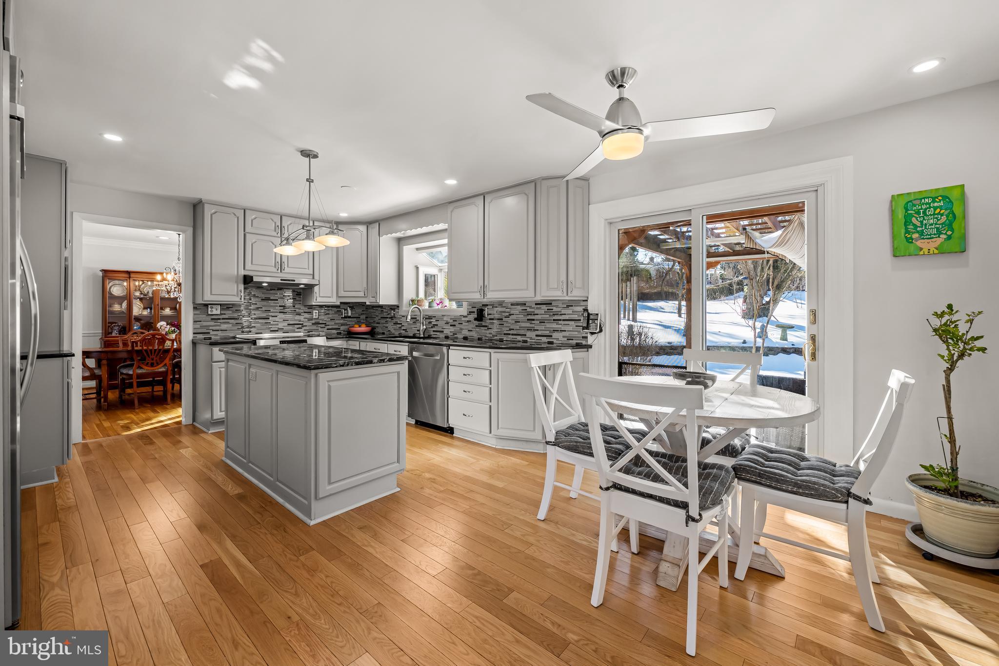3407 Birch Hollow Road Baltimore, MD 21208 - Photo 14 of 47 a kitchen with stainless steel appliances kitchen island granite countertop wooden floors and white cabinets