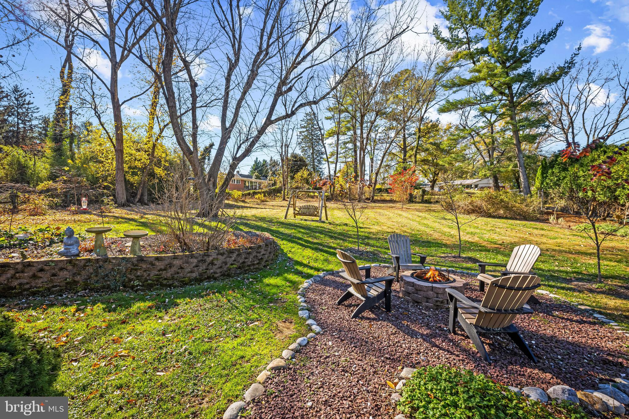 3407 Birch Hollow Road Baltimore, MD 21208 - Photo 24 of 47 a view of a backyard with lawn chairs under a large tree