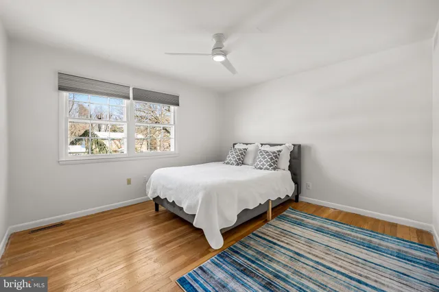 a spacious bedroom with a bed and wooden floor