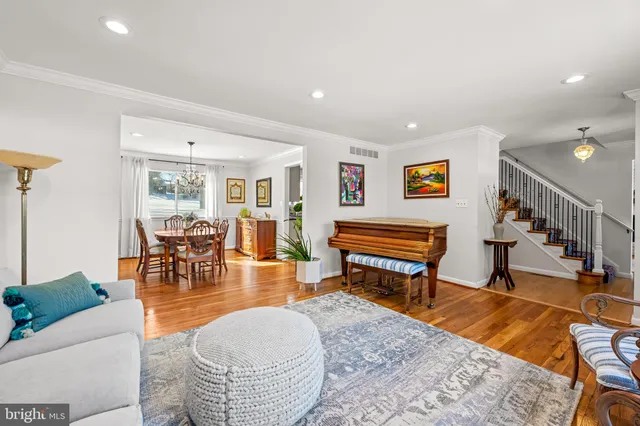 a living room with furniture and a dining table with wooden floor