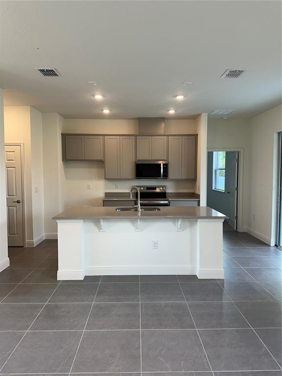 10776 Southwest 49th Ave Road Ocala, FL 34476 - Photo 3 of 9 a view of kitchen with stainless steel appliances granite countertop a sink counter top space and cabinets