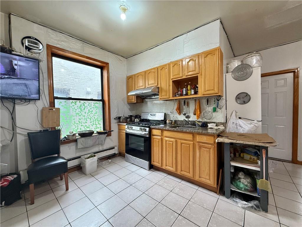 746 68th Street Brooklyn, NY 11220 - Photo 4 of 12 a kitchen with stainless steel appliances granite countertop a stove a sink and a microwave