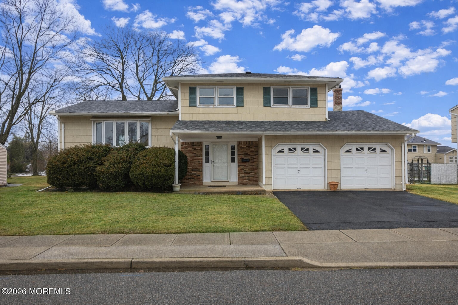 a front view of a house with a garden and yard