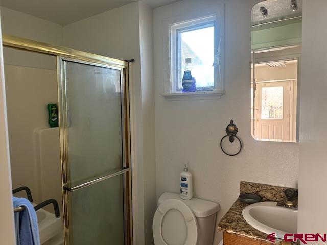 633 Alameda Cortez, CO 81321 - Photo 14 of 23 a bathroom with a granite countertop sink toilet and shower