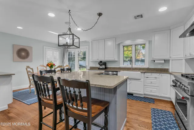 a kitchen with stainless steel appliances granite countertop a sink a stove and a refrigerator