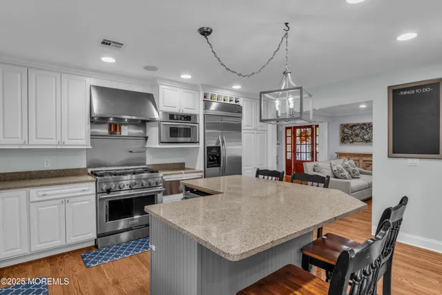 a kitchen with stainless steel appliances granite countertop a sink stove and wooden floor