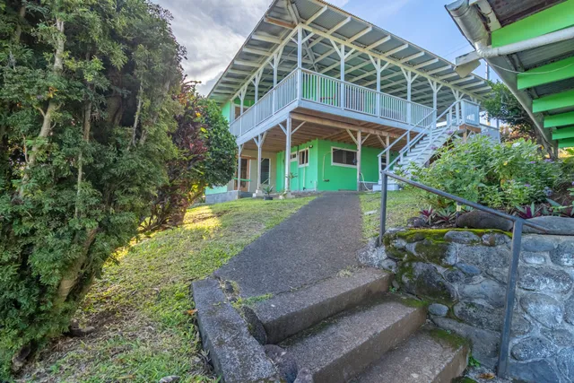 a view of a house with backyard and sitting area