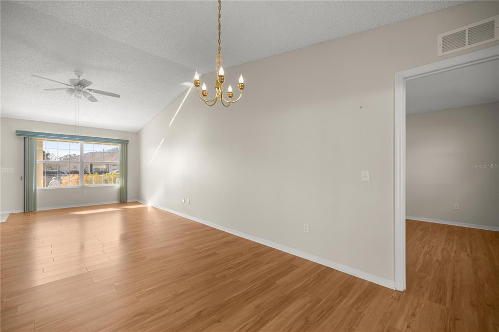 8478 Southwest 61st Terrace Road Ocala, FL 34476 - Photo 15 of 39 a view of empty room with wooden floor and chandelier