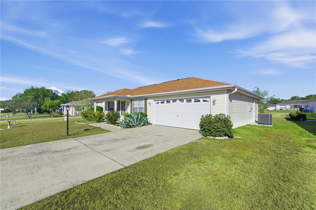 8478 Southwest 61st Terrace Road Ocala, FL 34476 - Photo 4 of 39 a front view of a house with a yard and garage