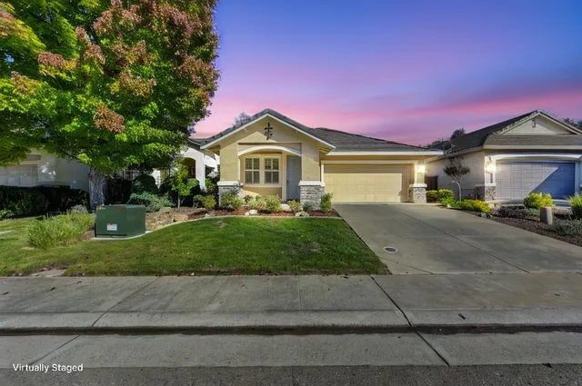 a front view of a house with a yard and garage