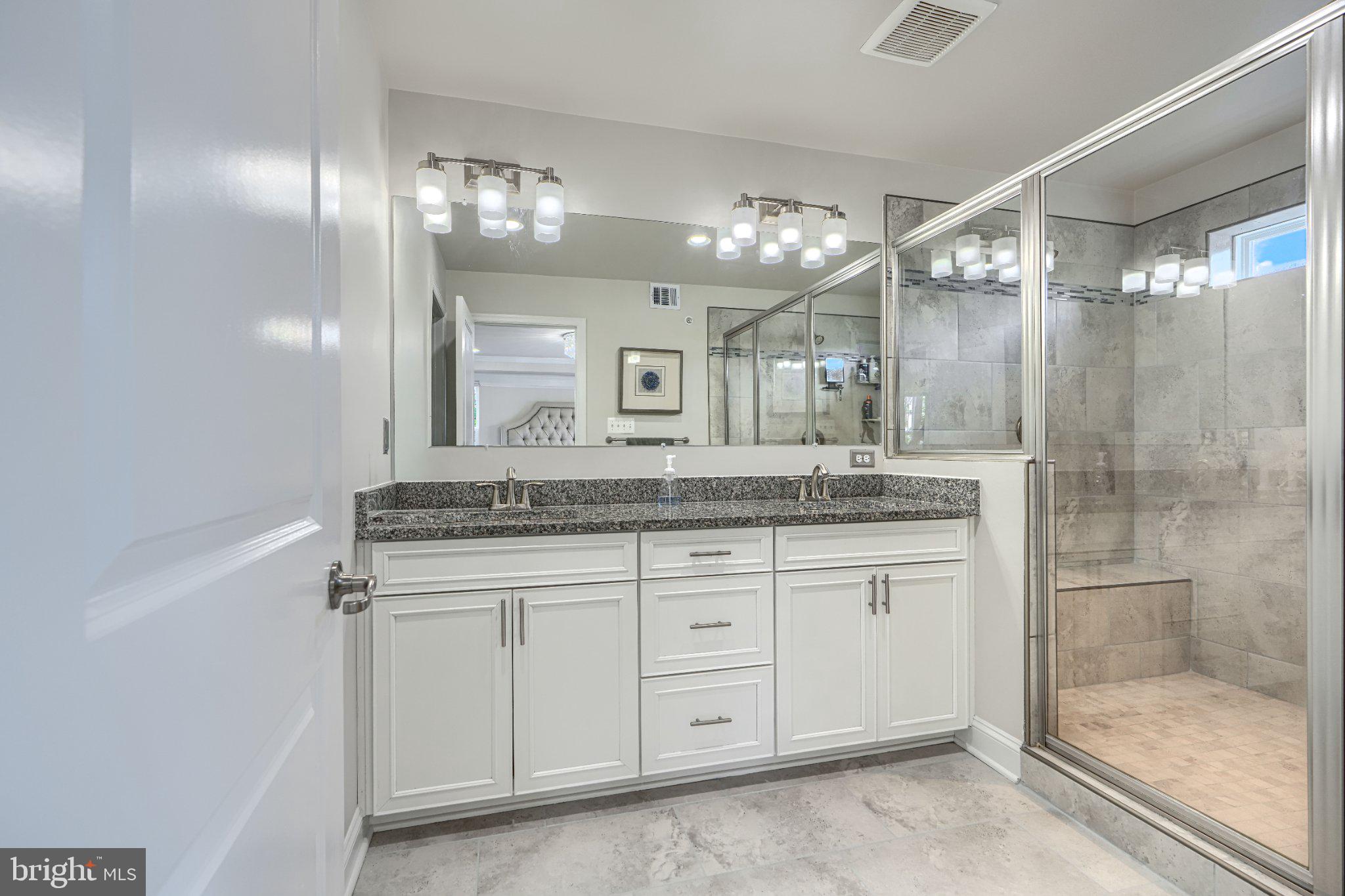 2707 Lady Slipper Road Gambrills, MD 21054 - Photo 37 of 60 a bathroom with a granite countertop sink a large mirror and a shower