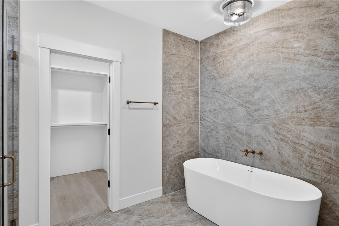 414 Blume Road Anderson, SC 29625 - Photo 36 of 50 Stone tile walls and a modern soaking tub define this elegant bathroom space.