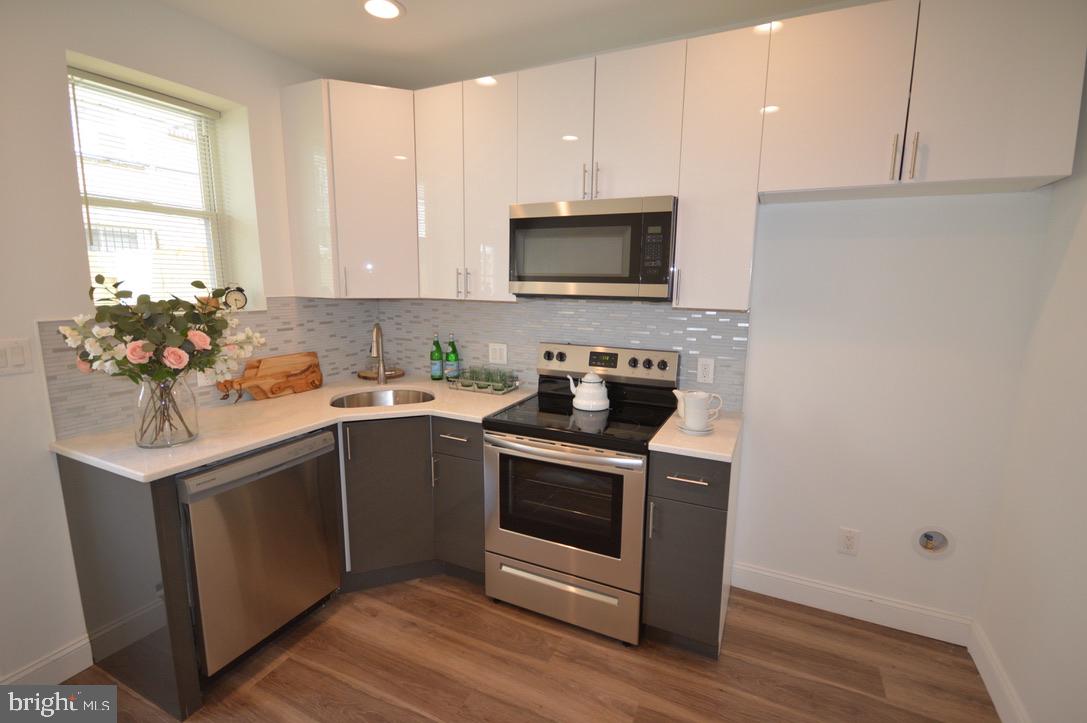 1827 Dudley Street Philadelphia, PA 19145 - Photo 1 of 15 a kitchen with a sink stove and microwave