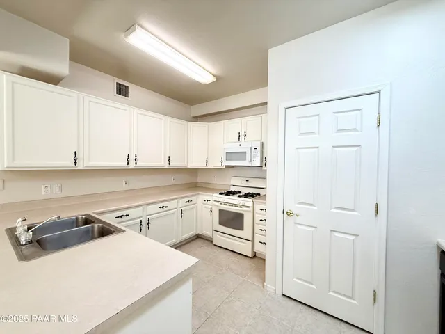 a kitchen with a stove sink and cabinets