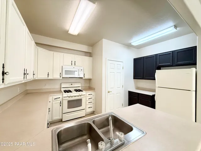 a kitchen with a refrigerator a stove top oven a sink and cabinets