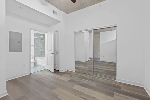 an empty room with wooden floor and chandelier fan