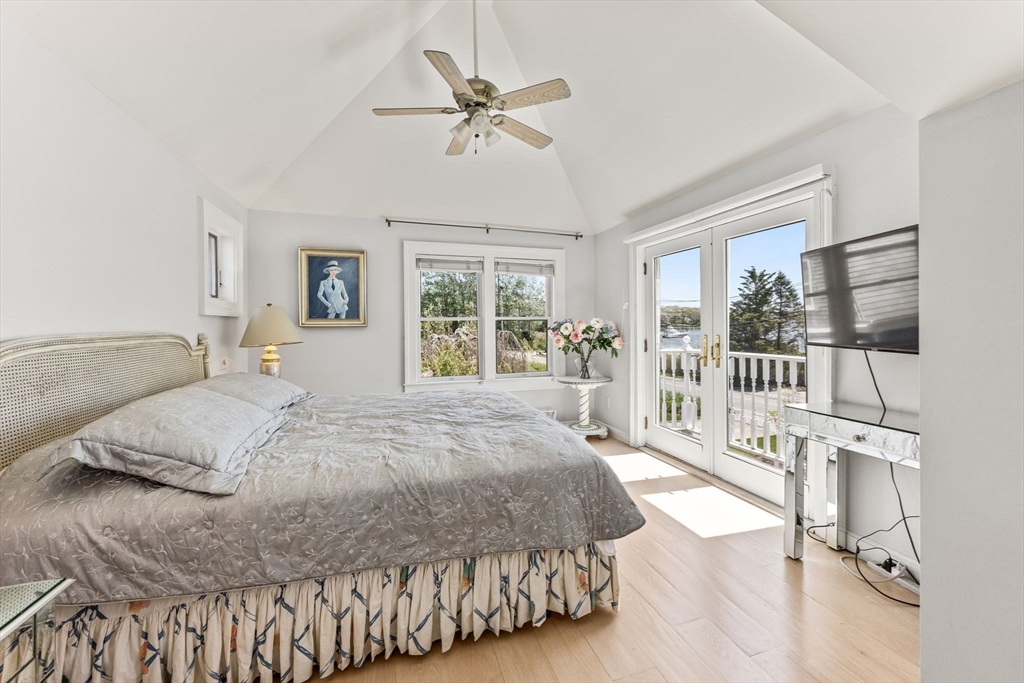 88 Bridge Street Barnstable, MA 02655 - Photo 24 of 36 a spacious bedroom with a large bed a chandelier and windows