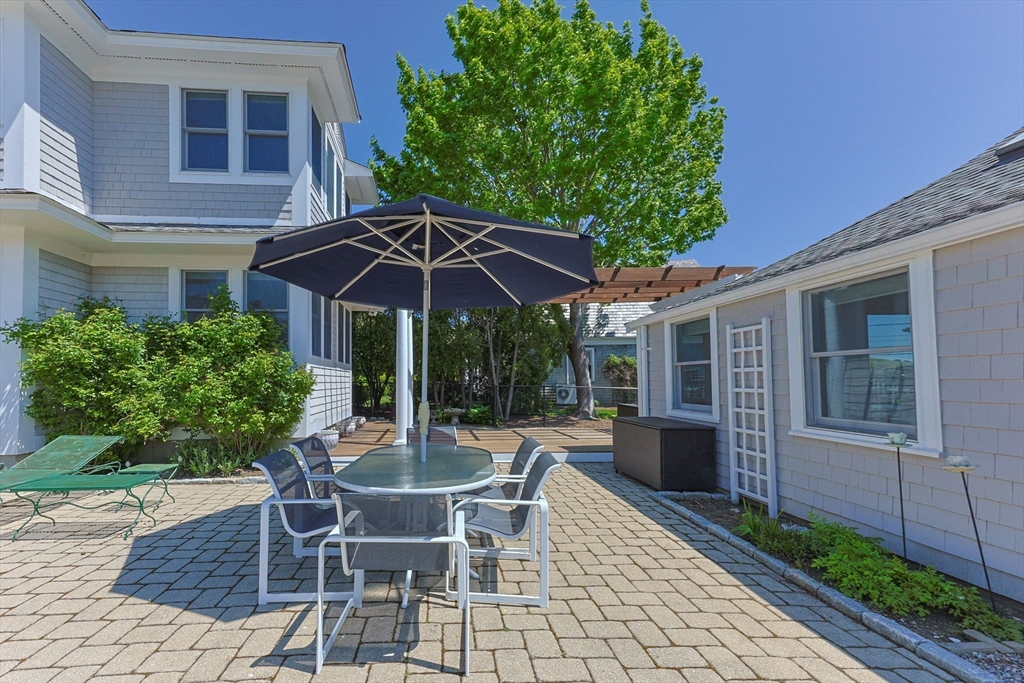 88 Bridge Street Barnstable, MA 02655 - Photo 7 of 36 a view of a patio with a table and chairs under an umbrella