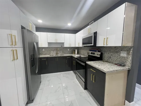 a kitchen with stainless steel appliances granite countertop refrigerator a sink a stove top oven a refrigerator and dishwasher