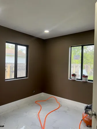 a bedroom with a bed and large windows