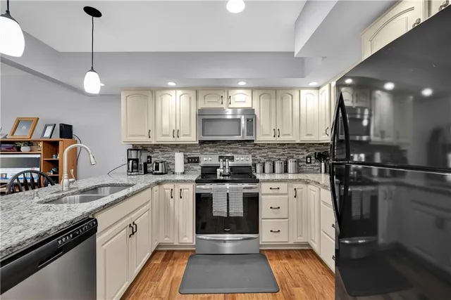 a kitchen with stainless steel appliances granite countertop a stove sink cabinets and refrigerator
