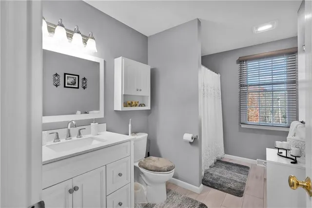 a bathroom with a sink toilet and window