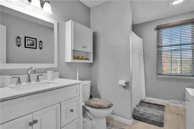 a bathroom with a granite countertop sink toilet and a mirror
