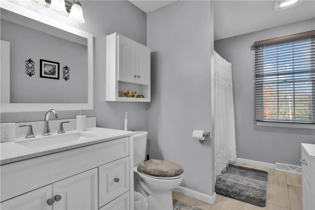 306 Acre Avenue Butler, PA 16001 - Photo 21 of 29 a bathroom with a granite countertop sink toilet and a mirror