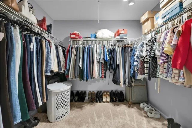 a view of walk in closet with clothes and shoes