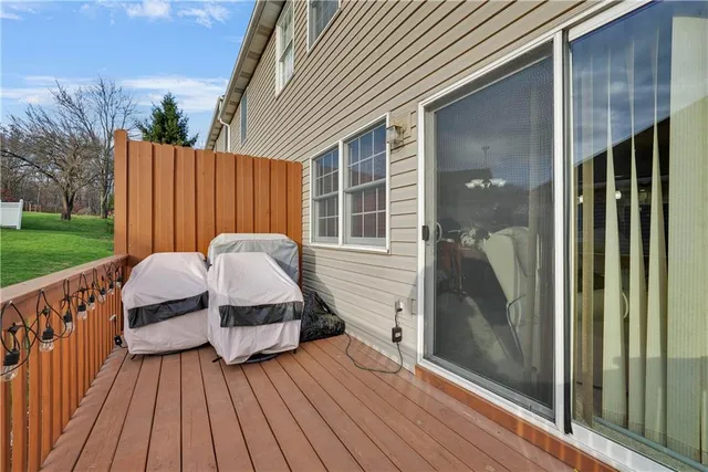 a front view of a house with barbeque and wooden fence