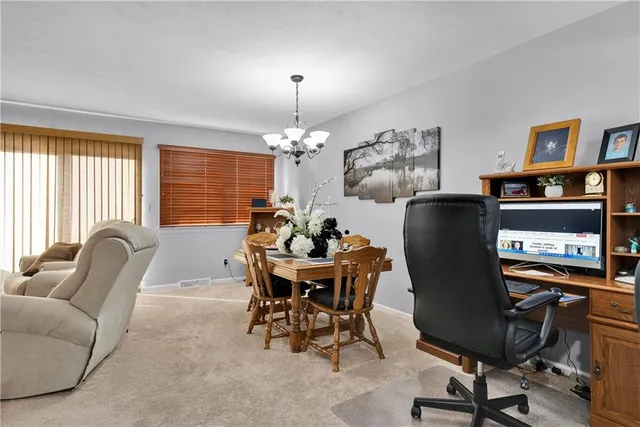 a view of a dining room with furniture and a chandelier