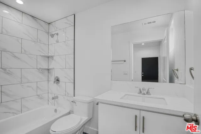 a bathroom with a sink toilet vanity and shower