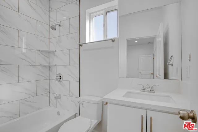 a bathroom with a sink toilet vanity and shower