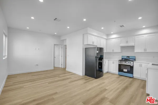 a view of kitchen with stainless steel appliances refrigerator stove microwave and cabinets