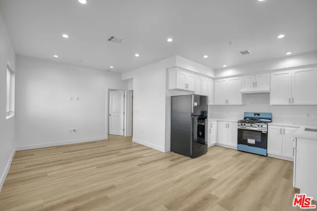 a view of kitchen with stainless steel appliances refrigerator stove microwave and cabinets