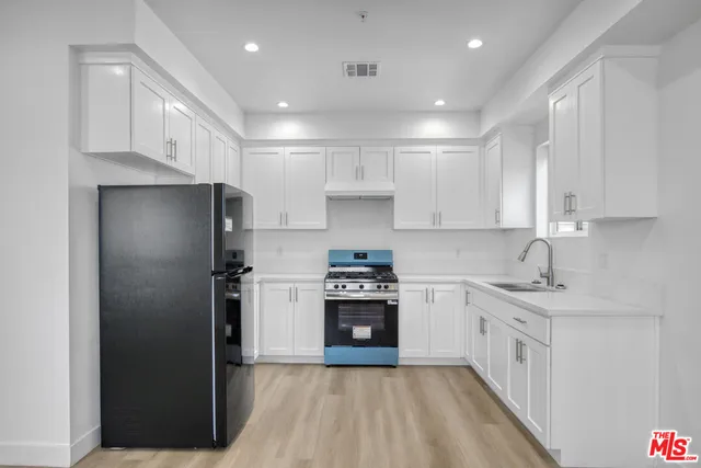 a kitchen with a sink stove and refrigerator