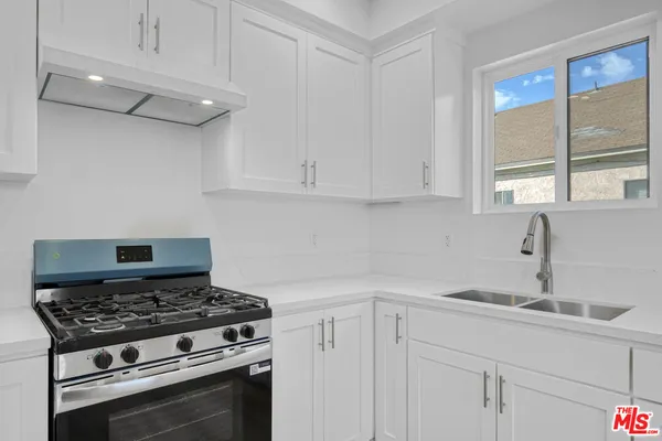 a kitchen with white cabinets and appliances