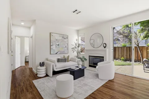 a living room with furniture a fireplace and a floor to ceiling window