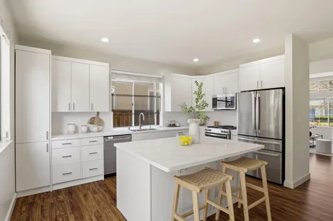 a kitchen with stainless steel appliances a stove a sink cabinets and a refrigerator