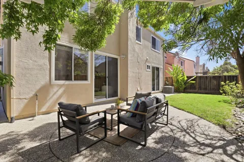 a view of a house with backyard and sitting area