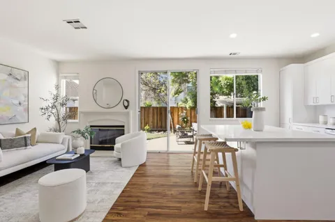 a living room with furniture a fireplace and a large window