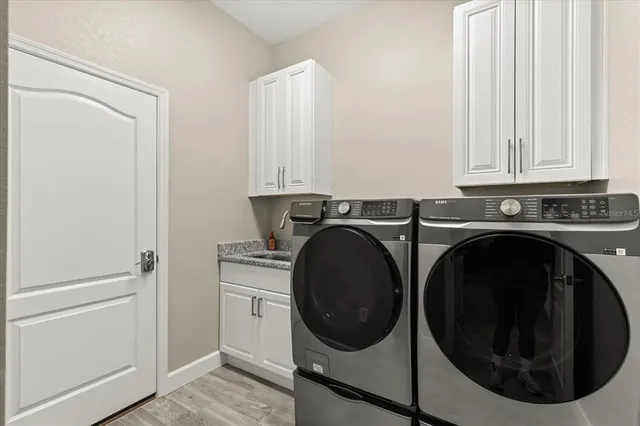 a utility room with sink dryer and washer