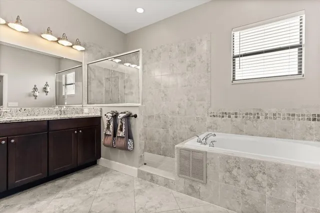 a spacious bathroom with a tub sink and mirror